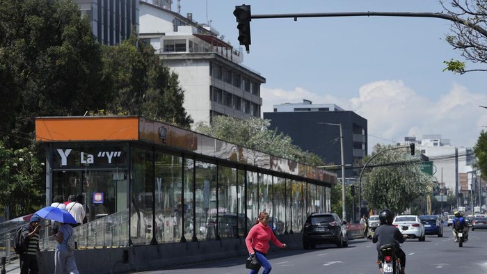 Imbas Kekeringan, Warga Ekuador Harus Hidup Minim Listrik A woman runs across an avenue where traffic lights are not working due to a programed power cut ordered by the ministry of energy, in Quito, Ecuador, Tuesday, April 16, 2024. Ecuador faces electricity rationing due to a prolonged drought and high temperatures that have reduced flows to the main hydroelectric plants. (AP Photo/Dolores Ochoa)