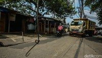 Kabel fiber optik yang terus menumpuk ini membuatnya kendur dan terputus akibat tersambar kendaraan.