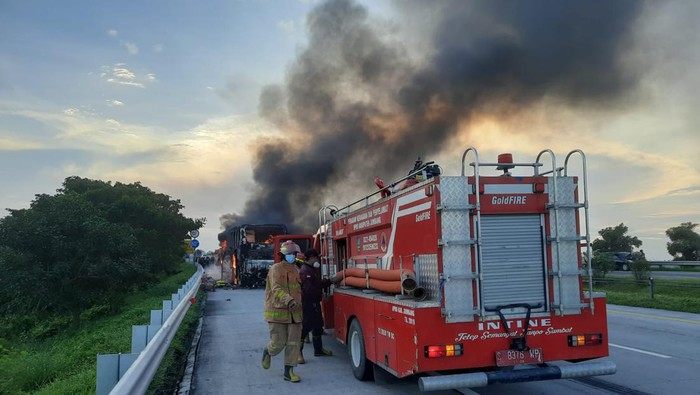 Mobil pemadam kebakaran memadamkan api yang membakar Bus Pahala Kencana di Tol Jombang-Mojokerto