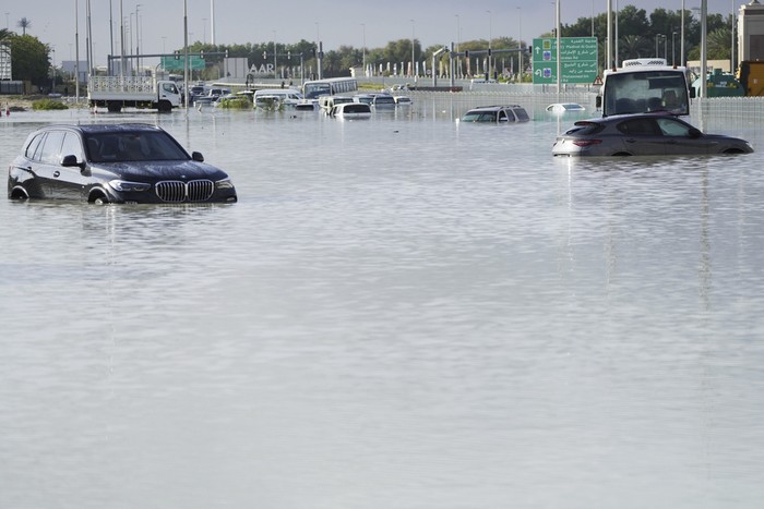 Vehicles sit abandoned in floodwater covering a major road in Dubai, United Arab Emirates, Wednesday, April 17, 2024. Heavy thunderstorms lashed the United Arab Emirates on Tuesday, dumping over a year and a halfs worth of rain on the desert city-state of Dubai in the span of hours as it flooded out portions of major highways and its international airport. (AP Photo/Jon Gambrell)
