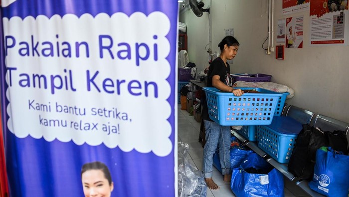 Dua pekerja memasukkan pakaian kotor ke dalam mesin cuci di salah satu usaha cuci pakaian di kawasan Kuningan, Jakarta, Rabu (17/4/2024). Jasa cuci pakaian mengalami peningkatan permintaan pascalibur Lebaran hingga sebanyak 45 tabung cuci per hari dibandingkan hari biasa sebanyak 30 tabung cuci per hari karena menjadi alternatif untuk meringankan pekerjaan rumah bagi masyarakat yang mudik. ANTARA FOTO/Sulthony Hasanuddin/wpa.