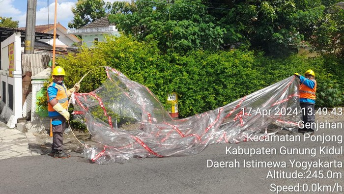Petugas PLN saat mengevakuasi balon udara yang menyangkut di tiang listrik di Padukuhan Tanggulangin, Kalurahan Genjahan, Kapanewon Ponjong, Gunungkidul, Rabu (17/4/2024) siang.