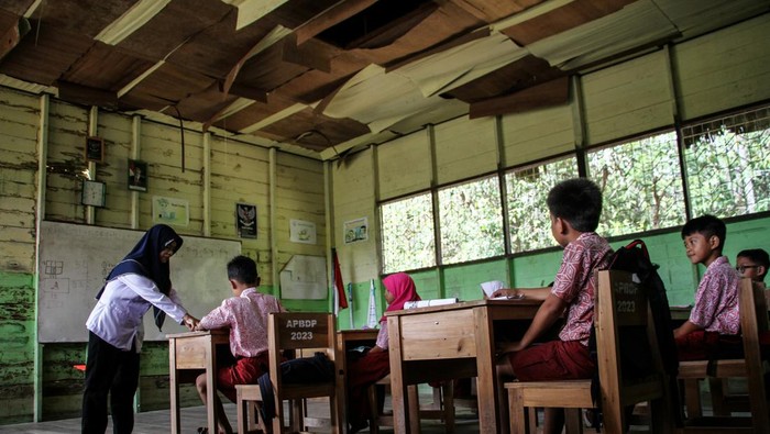 Sekolah rusak di Palangka Raya Seorang guru menyampaikan materi kepada siswa saat kegiatan belajar mengajar di kelas dengan kondisi plafon rusak di SD Negeri Petuk Katimpun 01 Palangka Raya, Kalimantan Tengah, Rabu (17/4/2024). Menurut kepala sekolah setempat, sejak lima tahun terakhir sebanyak tiga ruang kelas di sekolah tersebut mengalami kerusakan pada bagian dinding dan plafon sehingga membahayakan kegiatan belajar mengajar. ANTARA FOTO/Auliya Rahman/rwa.