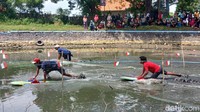 Dengan menggunakan papan luncur dan menggunakan kekuatan kaki dan tangan. Mereka berlomba menjadi yang terbaik.