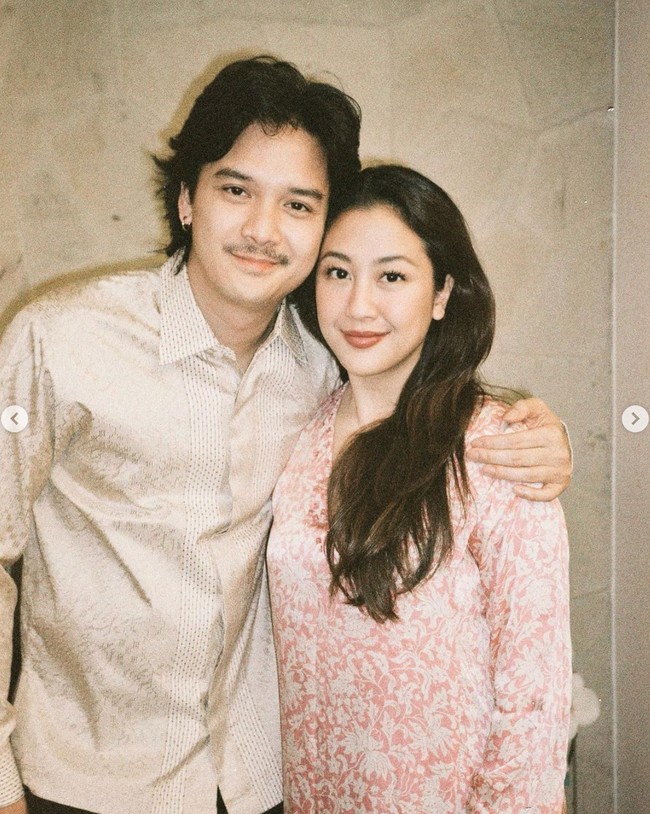 Tampil sederhana mengikuti sang istri, Baskara Mahenra rupanya juga mengenakan baju yang dipinjam dari mertuanya, Triawan Munaf. Terlihat Baskara mengenakan kemeja lengan panjang berwarna soft gold. Foto: Instagram/@sherinamunaf