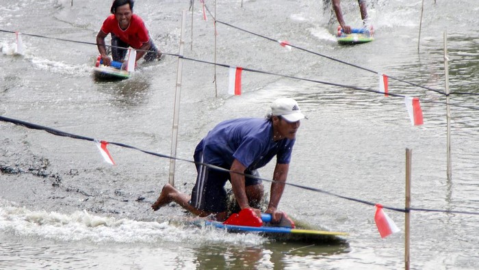 Peserta mendorong papan Ski Lot atau selancar lumpur di kolam Desa Tambaklekok, Lekok, Pasuruan, Jawa Timur, Rabu (17/4/2024). Ski Lot merupakan tradisi yang dilakukan masyarakat sekitar pesisir laut dalam merayakan Lebaran Ketupat. ANTARA FOTO/Umarul Faruq/rwa.