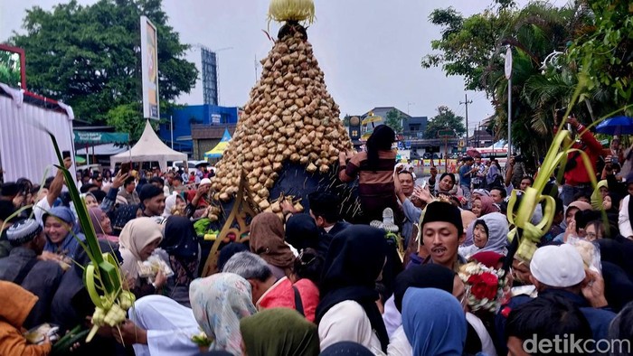 Warga berebut gunungan ketupat di Alun-Alun Kota Batu.