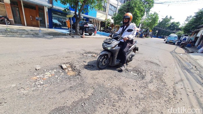 Pengendara menghindari jalan rusak di Jalan Asem Baris Raya, Tebet, Jakarta Selatan, Kamis (18/4/2024). Jalan rusak ini awalnya karena adanya proyek gorong-gorong drainase namun menurut warga setelah proyek selesai jalan yang rusak tidak kunjung diperbaiki. Dilokasinya sering terjadi pengendara motor yang terjatuh karena jalan yang rusak.