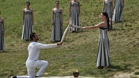Ketika prosesi tiba di Stadion, pendeta wanita tertinggi menyalakan obor pealri pertama dan estafet obor dimulai. Milos Bicanski/Getty Images.