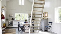 Rumah tanpa sekat adalah salah satu trik agar tampilannya terlihat lebih luas. Dapur minimalis berikut juga tidak membuat sekat antara tangga, meja makan, dan dapur. Meja dapur dipasang di pojok ruangan tanpa ada kabinet di atas sehingga cahaya matahari dapat masuk maksimal ke dalam rumah. Foto: Magnus Anesund via Elle Decor