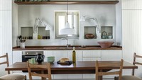 Dapur minimalis ini mengandalkan kabinet dan lemari di bagian bawah dan samping untuk menyimpan perabotan dapur sehingga terlihat rapih. Jendela di tengah cukup untuk ventilasi membuang asap atau hawa panas dari kompor. Perhatikan juga jarak dapur dengan meja makan, pastikan tidak terlalu dekat terutama bagi yang menggunakan kayu atau besi. Foto: Ricardo Labougle via Elle Decor