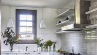 Dapur minimalis satu ini berbentuk L dengan memanfaatkan lemari kabinet di bagian bawah dan rak terbuka di atasnya. Meskipun jendela tidak berada di atas kompor tetapi cahaya tetap dapat masuk dan menerangi langsung ke arah kompor. Dinding di sekitar kompor juga dipasang keramik agar tidak terlihat kusam. Foto: William Waldron via Elle Decor