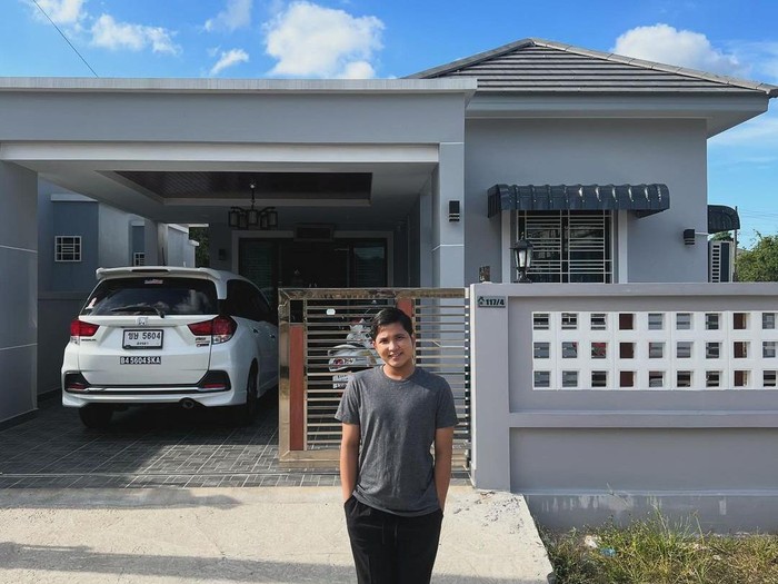 Jirayut berfoto di depan rumah barunya di Thailand.
