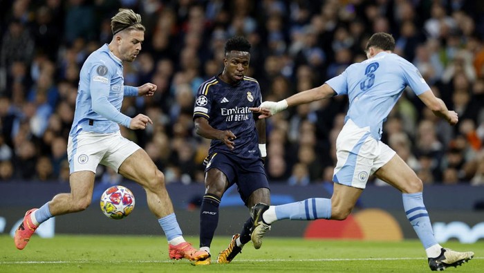 Soccer Football - Champions League - Quarter Final - Second Leg - Manchester City v Real Madrid - Etihad Stadium, Manchester, Britain - April 17, 2024 Real Madrids Vinicius Junior in action with Manchester Citys Jack Grealish and Ruben Dias Action Images via Reuters/Jason Cairnduff