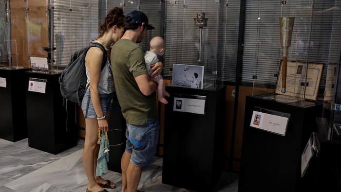 A visitor looks at the exhibits from the collection of Stratos Klimou, during a temporary exhibition of historic Olympic torches in Ancient Olympia, Greece, April 16, 2024. REUTERS/Louisa Gouliamaki