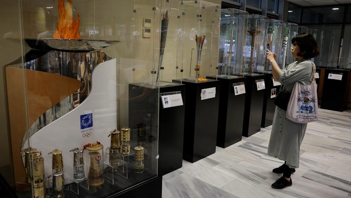 A visitor looks at the exhibits from the collection of Stratos Klimou, during a temporary exhibition of historic Olympic torches in Ancient Olympia, Greece, April 16, 2024.  REUTERS/Louisa Gouliamaki