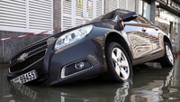 Sebuah mobil nampak masuk ke saluran air saat banjir terjadi. Curah hujan yang tinggi kemungkinan besar disebabkan oleh sistem cuaca normal yang diperburuk oleh perubahan iklim, kata para ahli.
