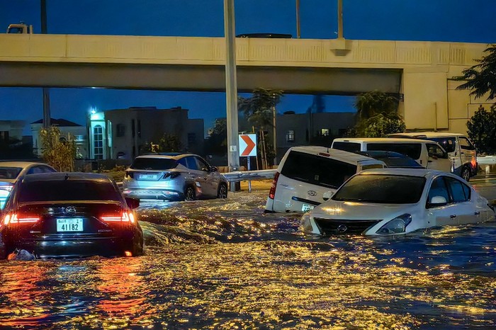 Cars drive in a flooded street following heavy rains in Dubai on April 17, 2024. Dubai, the Middle Easts financial centre, has been paralysed by the torrential rain that caused floods across the UAE and Bahrain and left 18 dead in Oman on April 14 and 15. (Photo by Giuseppe CACACE / AFP)
