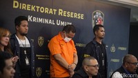 PWGA tertunduk saat dipamerkan sebagai tersangka. PWGA memakai pelat dinas TNI dan mengaku-aku sebagai adik jenderal.