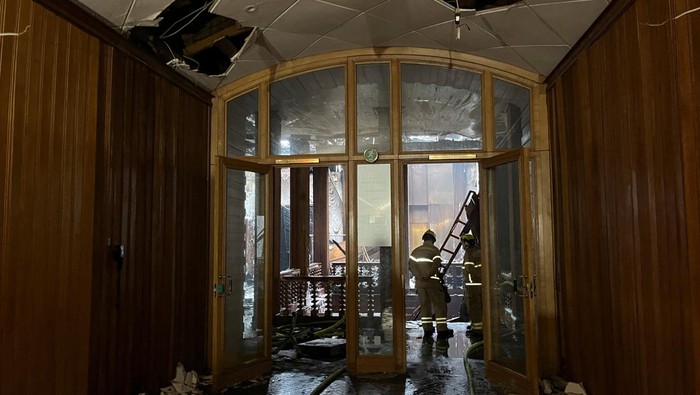 Penampakan Gedung Bursa Efek Bersejarah di Denmark Pasca Terbakar Hebat Fire crew members work inside the Old Stock Exchange building, following a fire in Copenhagen, Denmark, April 17, 2024. REUTERS/Louise Breusch Rasmussen