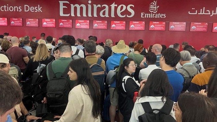 A woman and her daughters eat as they wait for their flight after a rainstorm hit Dubai, causing delays at Dubai International Airport, United Arab Emirates, April 17, 2024. REUTERS/Staff REFILE - QUALITY REPEAT