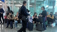 Orang-orang menunggu penerbangan mereka setelah hujan badai melanda Dubai di Bandara Internasional Dubai, Uni Emirat Arab, Rabu (17/4/2024).  