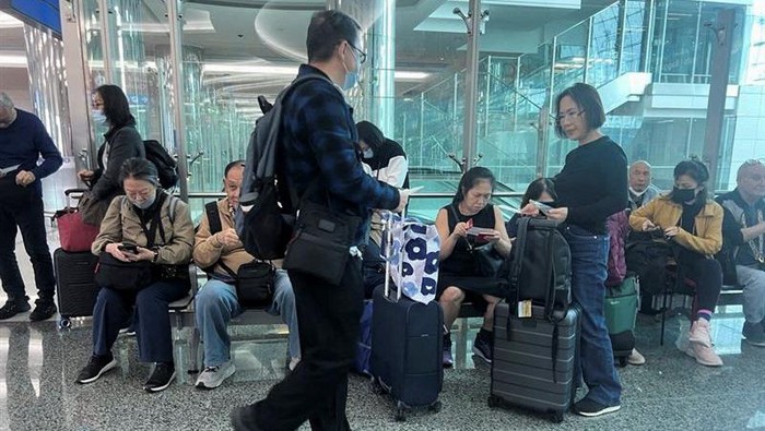 A woman and her daughters eat as they wait for their flight after a rainstorm hit Dubai, causing delays at Dubai International Airport, United Arab Emirates, April 17, 2024. REUTERS/Staff REFILE - QUALITY REPEAT