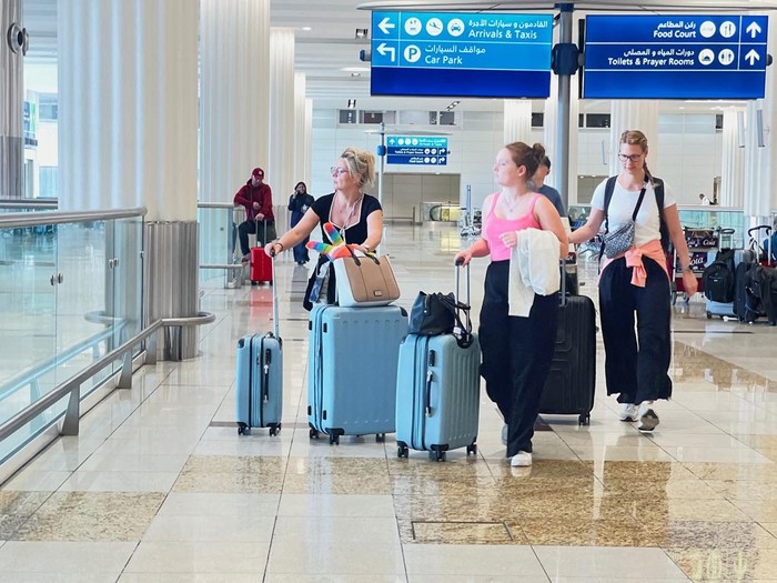 A woman and her daughters eat as they wait for their flight after a rainstorm hit Dubai, causing delays at Dubai International Airport, United Arab Emirates, April 17, 2024. REUTERS/Staff REFILE - QUALITY REPEAT