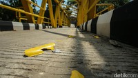 Petugas juga nampak telah ada di lokasi untuk merapikan cat jembatan kuning tersebut.  