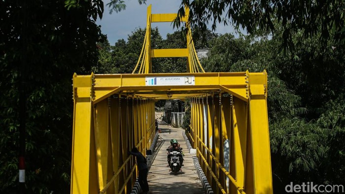 Rampung Bulan Lalu, Cat Jembatan Kuning Depok Mulai Terkelupas Jembatan gantung berwarna kuning di Depok baru saja rampung sekitar satu bulan yang lalu. Namun, cat kuning tersebut ada yang terkelupas.