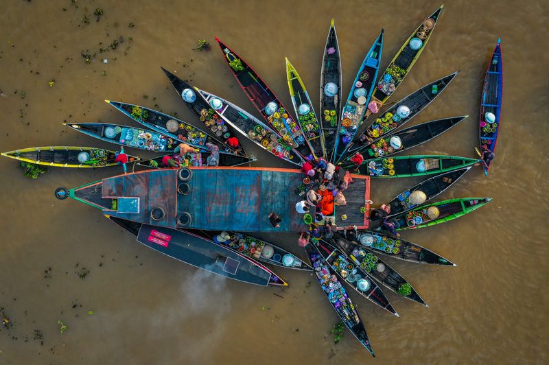 Foto udara sejumlah pedagang menjajakan dagangannya di atas perahu (jukung) di Pasar Terapung Lok Baintan, Kabupaten Banjar, Kalimantan Selatan, Kamis (18/4/2023). Pasar yang berada di aliran Sungai Martapura tersebut merupakan pasar tradisional yang menjual beragam dagangan hasil produksi pertanian dan perkebunan masyarakat setempat dari atas Jukung. ANTARA FOTO/Bayu Pratama S/aww.