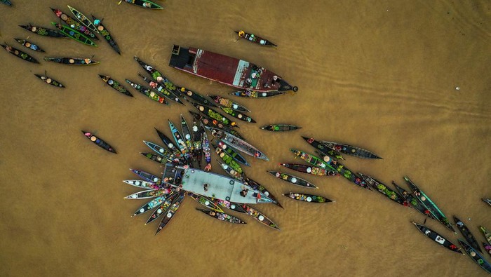 Foto udara sejumlah pedagang menjajakan dagangannya di atas perahu (jukung) di Pasar Terapung Lok Baintan, Kabupaten Banjar, Kalimantan Selatan, Kamis (18/4/2023). Pasar yang berada di aliran Sungai Martapura tersebut merupakan pasar tradisional yang menjual beragam dagangan hasil produksi pertanian dan perkebunan masyarakat setempat dari atas Jukung. ANTARA FOTO/Bayu Pratama S/aww.