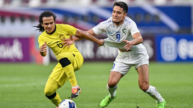Ulugbek Khoshimov (R) from Uzbekistan is battling for the ball with Muhammad Naimudin Akmal (L) from Malaysia during the AFC U23 Asian Cup Qatar 2024 Group D match between Uzbekistan and Malaysia at Khalifa International Stadium in Doha, Qatar, on April 17, 2024. (Photo by Noushad Thekkayil/NurPhoto via Getty Images)