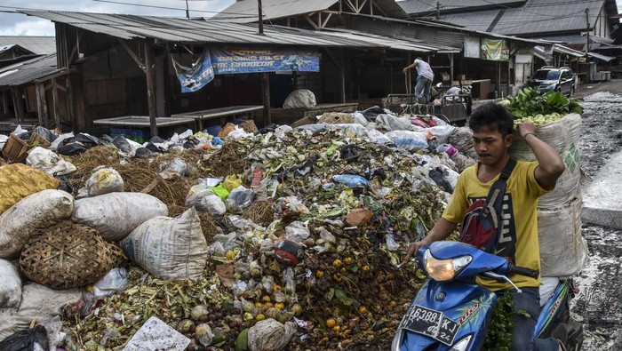 Warga melintasi tumpukan sampah yang menutupi akses jalan di Pembuangan Akhir Sementara,  Pasar Cikurubuk, Kota Tasikmalaya, Jawa Barat, Kamis (18/4/2024). Dinas Lingkungan Hidup Kota Tasikmalaya mencatat volume sampah di Kota Tasikmalaya selama Lebaran meningkat 20 persen atau sebanyak  230-240 ton per hari dibanding hari biasa mencapai 180-200 ton per hari. ANTARA FOTO/Adeng Bustomi/rwa.