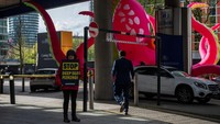 Para aktivis Greenpeace melakukan protes di luar Hilton, Canary Wharf pada pagi pembukaan KTT Tambang Laut Dalam tahunan.