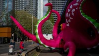 Aktivis Greenpeace melakukan protes dengan menggunakan gurita tiup setinggi bus tingkat di luar Canary Wharf Hilton, London.