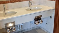 Kamar mandi di salah satu supermarket di Italia ini seakan membuat pengunjung menyalakan keran air menggunakan lututnya, karena keran tersebut berada di bawah. Foto: Pool/Site