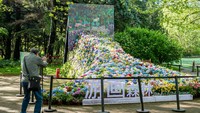 Tampak seorang pengunjung mengabadikan sekumpulan bunga berwarna-warni yang ada di taman hutan Gongqing.
