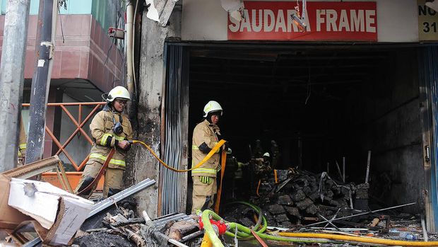 Sejumlah petugas pemadam kebakaran melakukan pendinginan ruko Saudara Frame dan Galery yang terbakar di Jalan Mampang Prapatan, Jakarta, Jumat (19/4/2024). Menurut Kapolsek Mampang Prapatan, Jakarta Selatan, Kompol David Yunior Kanitero, menyebut tujuh korban meninggal dunia akibat kebakaran di ruko tersebut ditemukan dalam satu ruangan yang berada di lantai dua. ANTARA FOTO/Reno Esnir/YU