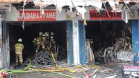 Sejumlah petugas damkar melakukan pendinginan di toko bingkai yang terletak di Jalan Mampang Prapatan, Jakarta, Jumat (19/4/2024).