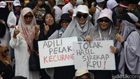 Massa membawa berbagai spanduk dan poster.