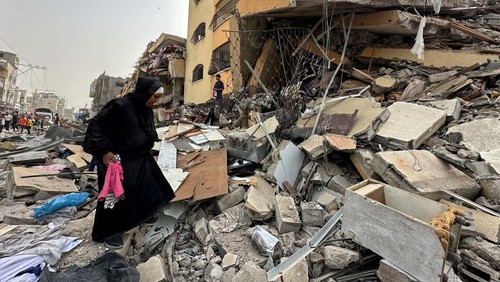 Palestinian women react as they sit on the rubble of a residential building housing their apartments, following an Israeli raid, amid the ongoing conflict between Israel and the Palestinian Islamist group Hamas, in Nuseirat, in the central Gaza Strip, April 18, 2024. REUTERS/Doaa Rouqa