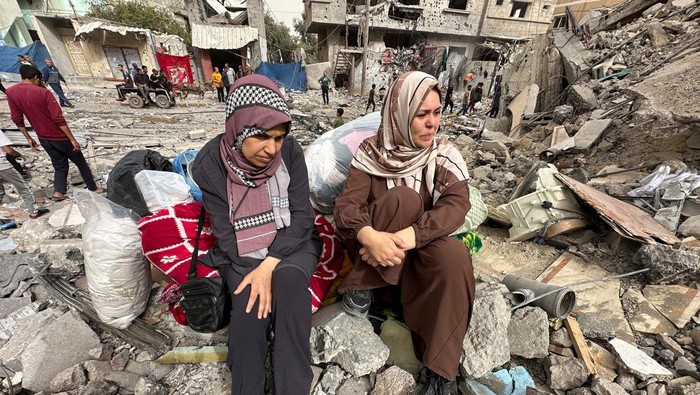Palestinian women react as they sit on the rubble of a residential building housing their apartments, following an Israeli raid, amid the ongoing conflict between Israel and the Palestinian Islamist group Hamas, in Nuseirat, in the central Gaza Strip, April 18, 2024. REUTERS/Doaa Rouqa