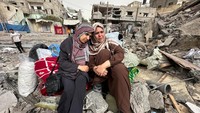 Wanita Palestina bereaksi ketika mereka duduk di reruntuhan bangunan tempat tinggal di Nuseirat, di Jalur Gaza tengah, 18 April 2024.