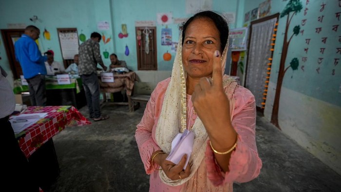 India Gelar Pemilu Terbesar di Dunia dengan Lebih dari 970 Juta Pemilih People stand on queue to cast their votes during the first round of polling of India's national election in Bahona village, Jorhat, northeastern Assam, India, Friday, April 19, 2024. Nearly 970 million voters will elect 543 members for the lower house of Parliament for five years, during staggered elections that will run until June 1. (AP Photo/Anupam Nath)