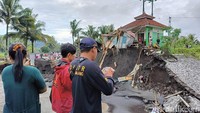 Sejumlah warga menyaksikan Jembatan Gondosuro yang terputus setelah diterjang banjir lahar dingin Semeru.