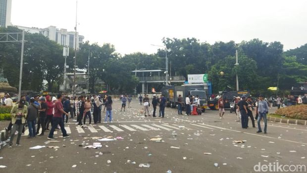 Massa kedua kubu membubarkan diri dari Patung Kuda. Petugas PPSU datang membersihkan sampah berserakan (Kurniawan F/detikcom)