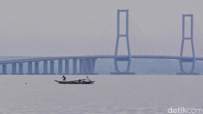 Nelayan Kenjeran melintas di bawah Jembatan Suramadu saat melaut
