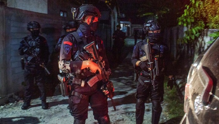 Penggeledahan rumah terduga anggota Jamaah Islamiyah di Palu Personel Birmob dan Tim Gegana Polda Sulteng berjaga di depan sebuah rumah saat penggeledahan oleh Densus 88 Anti Teror di Palu, Sulawesi Tengah, Kamis (18/4/2024). Densus 88 kembali menggeledah rumah seorang terduga anggota Jamaah Islamiyah (JI) yang ditangkap di wilayah Sulawesi Barat, setelah sebelumnya pada Selasa (16/4/2024) menangkap tujuh orang terduga anggota Jamaah Islamiyah di wilayah Palu, Sigi, dan Poso. ANTARA FOTO/Basri Marzuki/rwa.