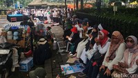 Para ibu-ibu menunggu dengan berkumpul di sekitar lokasi Salat Jumat.